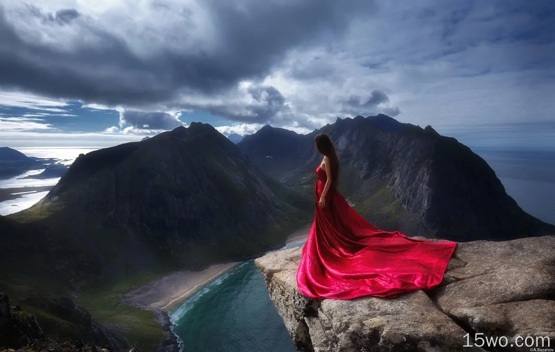 女孩穿着红色的衣服站在悬崖边的壁纸上
