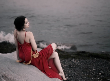 红色礼服的女孩坐岩石海滩8k壁纸 7360x4140