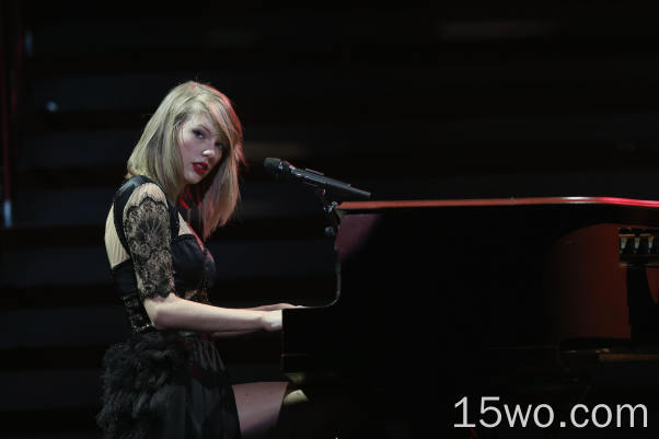 泰勒·斯威夫特，歌手，弹钢琴，金发，红色口红，黑色连衣裙